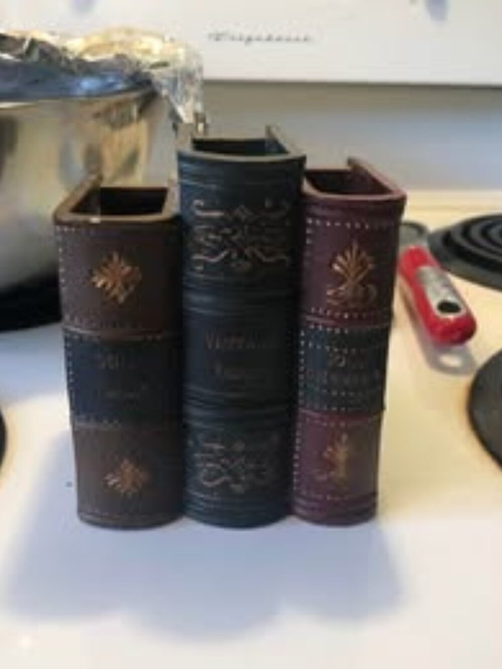 Decorative desk organizer is made of a resin material with a faux-leather book a